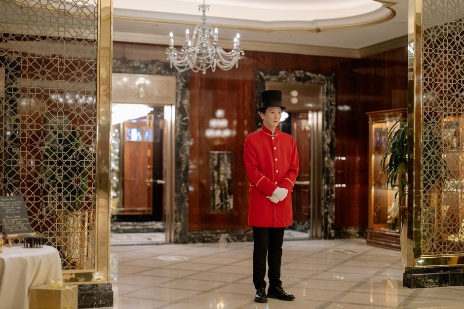 Portier en uniforme devant un palace parisien – conciergerie de luxe à Paris